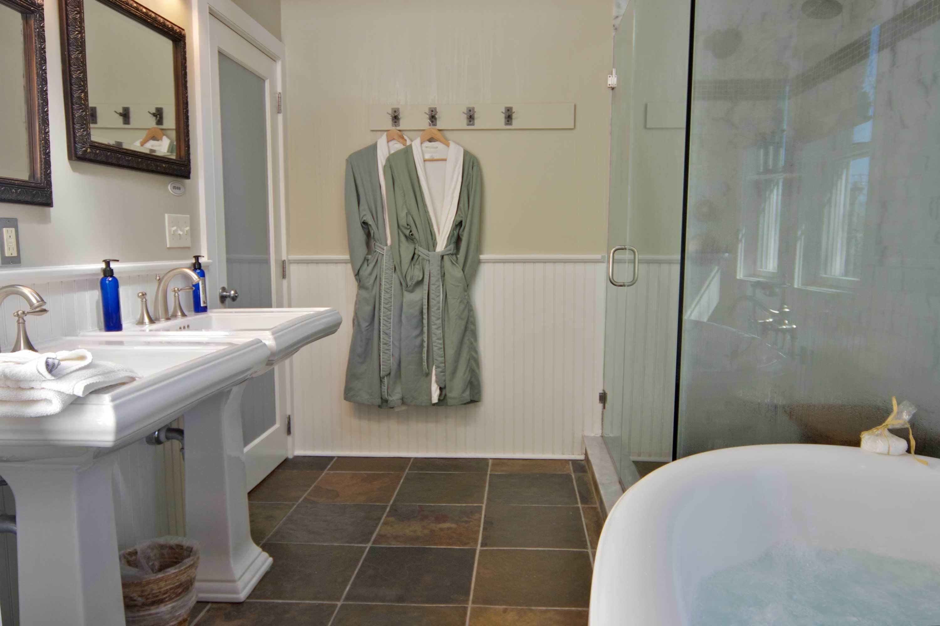 A bathroom with a white sink, a bathtub, and a glass shower enclosure.