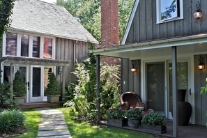 A house with a covered porch, a brick chimney, and a pathway leading to the front door.