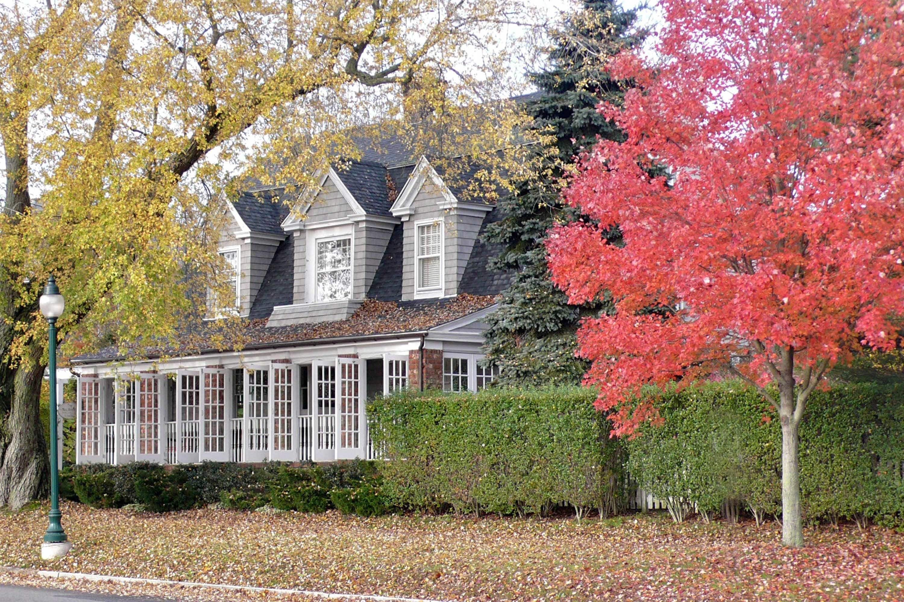 A large, two-story house with a wrap-around porch and a symmetrical facade.