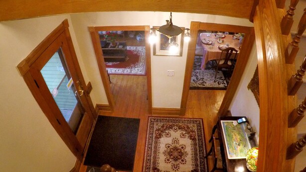 A staircase with wooden railings and a chandelier. - Niagara Inn Bed & Breakfast (Niagara Falls)