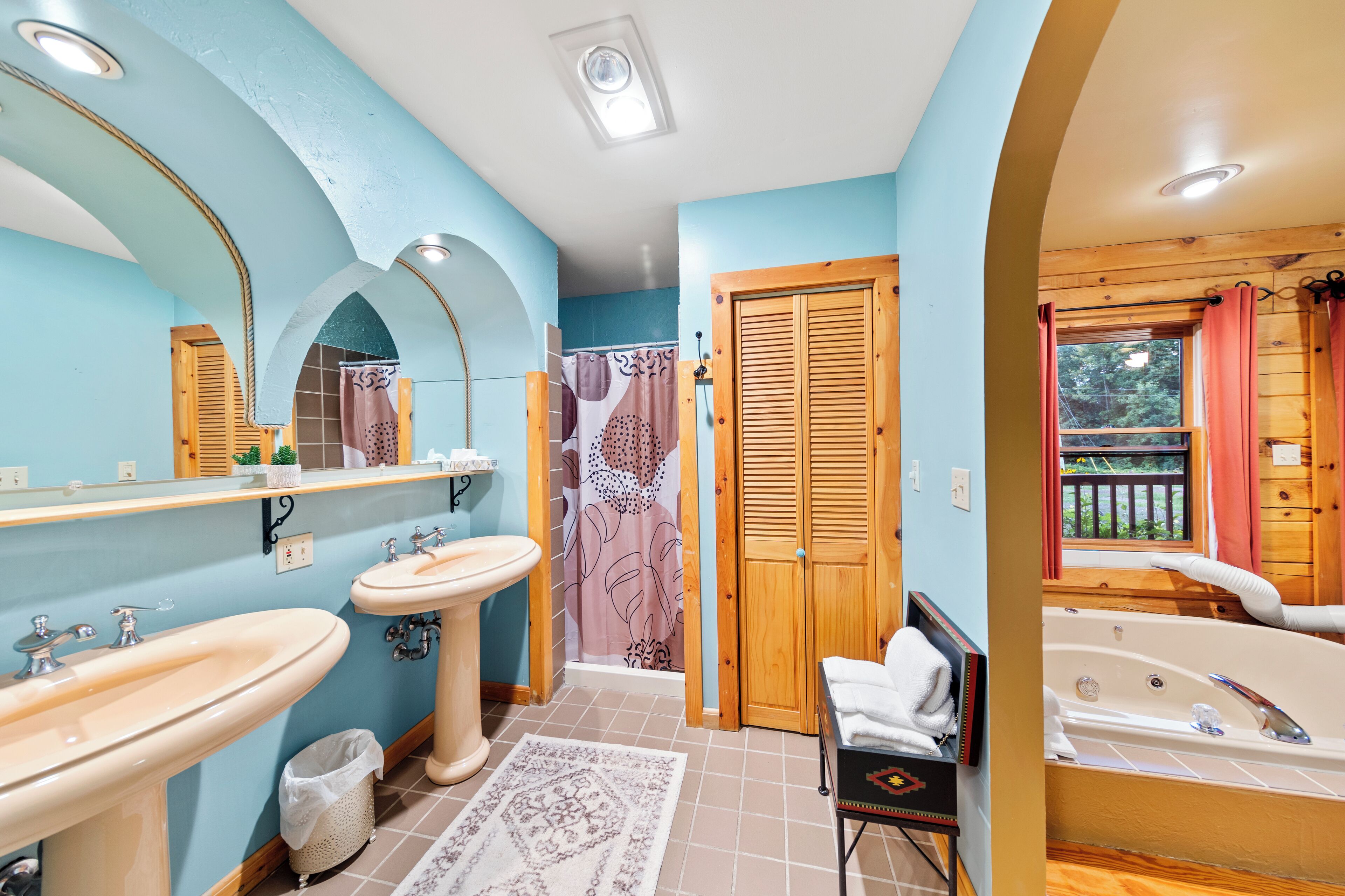 Une salle de bain avec deux lavabos, des toilettes, une douche et une baignoire.
