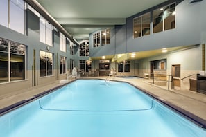 A large indoor swimming pool with a clear view of the pool area, adjacent rooms, and a staircase leading to an upper level. - Holiday Inn Express Hotel & Suites NORTH SEQUIM by IHG (Sequim)
