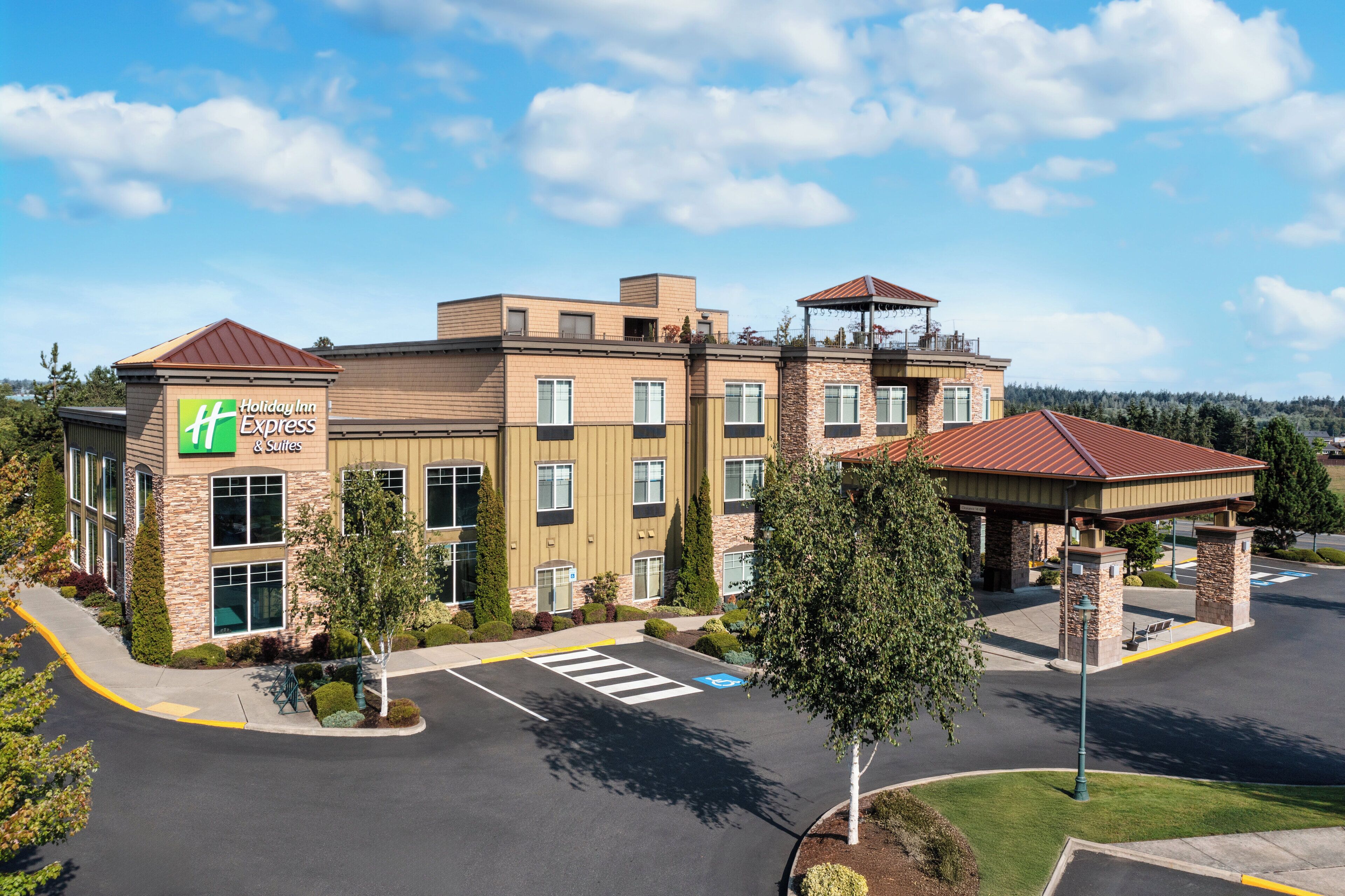 Un bâtiment de la chaîne Holiday Inn Express, doté d’un parking et d’un espace extérieur abrité.