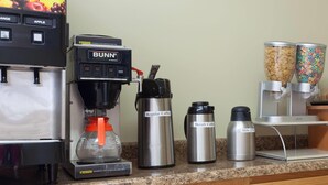 A coffee station with a Bunn coffee machine, decaffeinated and regular coffee options, and a milk dispenser. - Travelodge by Wyndham Seymour (Seymour)