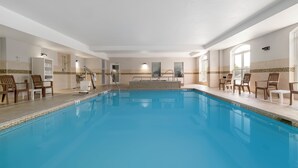 A swimming pool with chairs and a changing room.