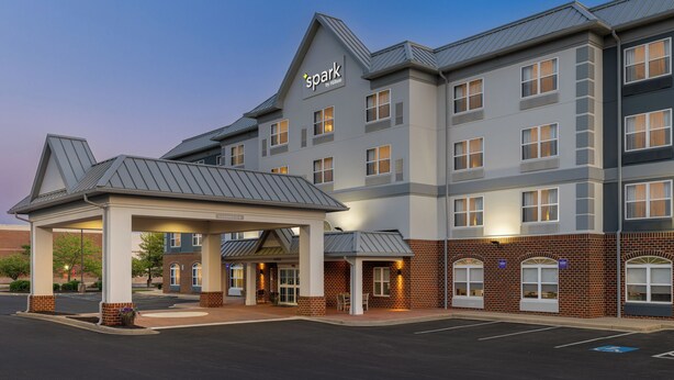 A multi-story hotel with a covered entrance, large windows, and a prominent brand sign.