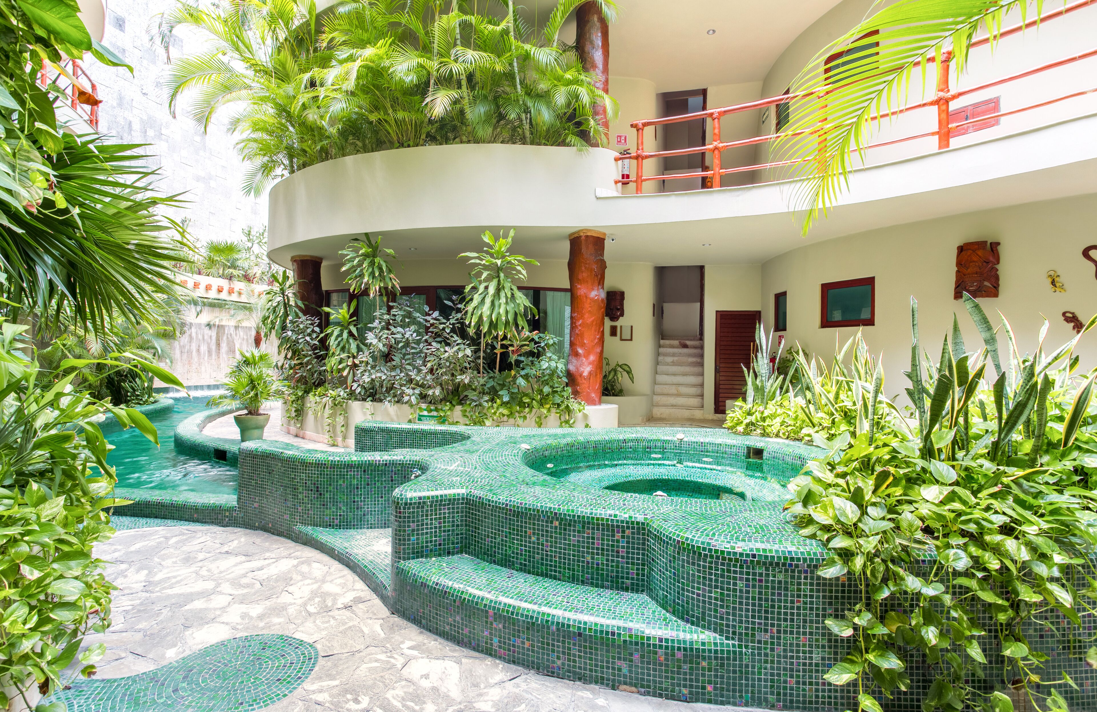 A multi-level indoor garden with a central water feature and tiered seating.