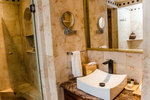 A bathroom with a marble sink, a large mirror, a towel rack, and a shower area. - Maya Villa Condo Hotel & Beach Club (Playa del Carmen)