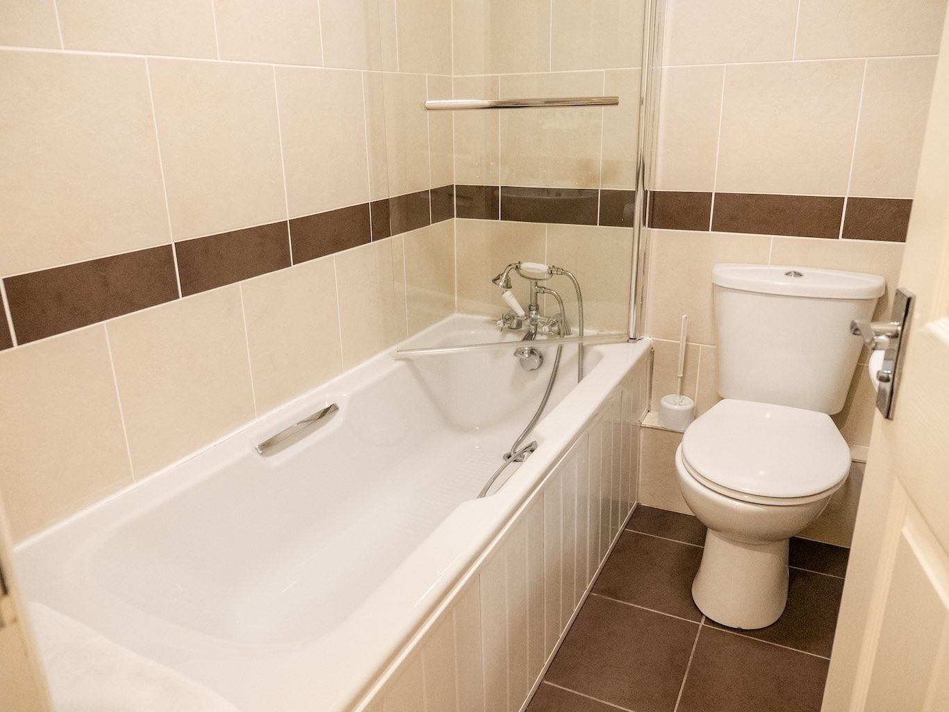 A bathroom with a bathtub, toilet, and shower.