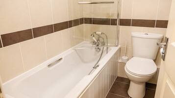 A bathroom with a bathtub, toilet, and shower.