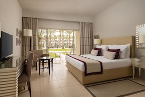 Ein Hotelzimmer mit einem Bett, einem Schreibtisch, einem Fernseher und Blick auf einen Innenhof.