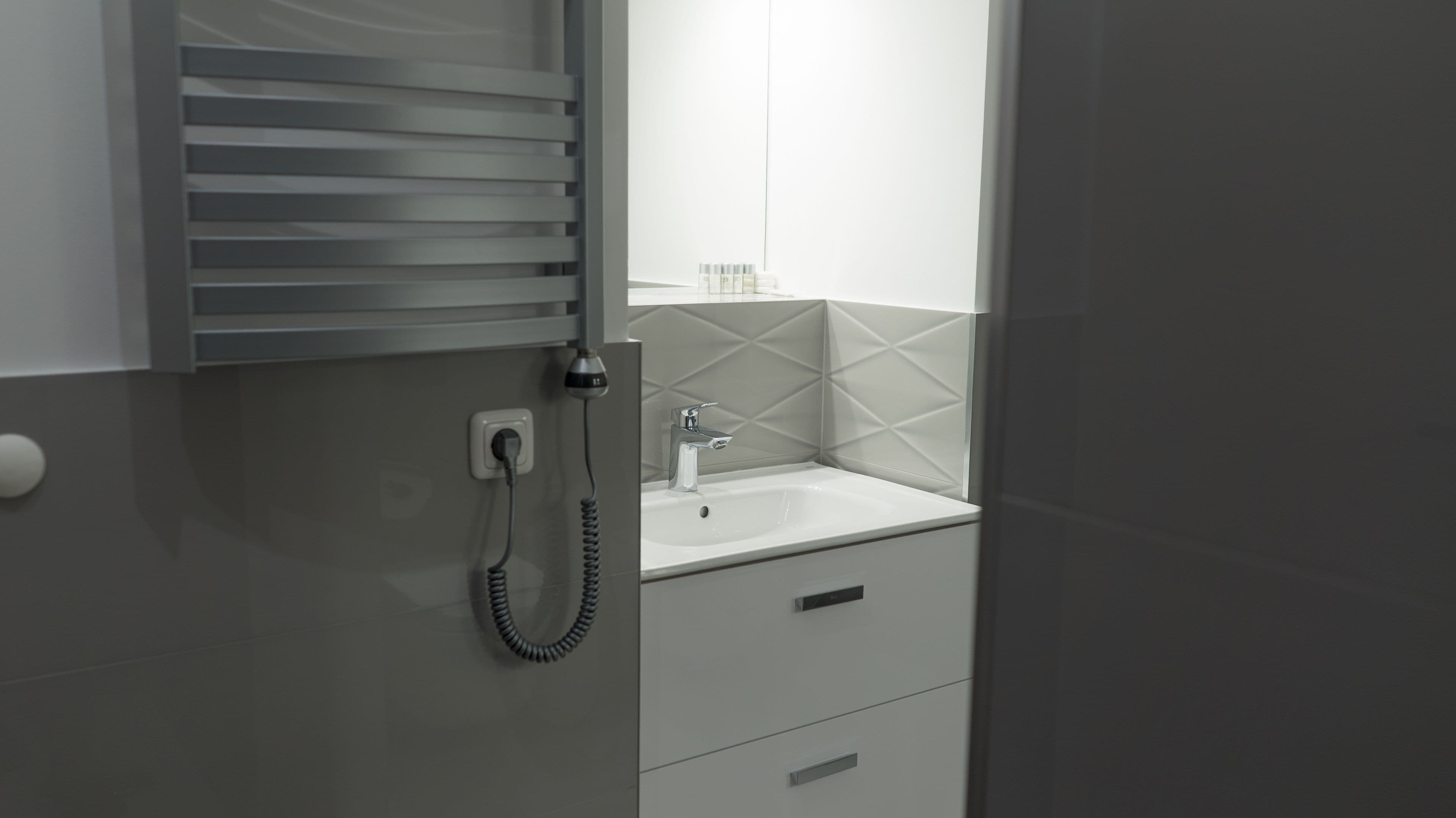 A modern bathroom with a built-in telephone, a sink, and a mirror.