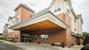 A multi-story building with a covered entrance and a clear sign indicating a clearance of 10 feet. - Fairfield Inn & Suites by Marriott Portsmouth Exeter (Exeter)