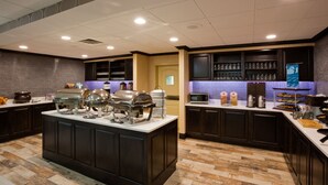 Une cuisine d’hôtel dotée d’un îlot central, d’un espace buffet et d’un bar.