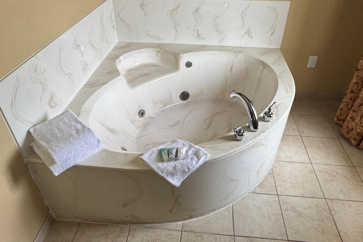 Un baño con una bañera independiente, una toalla y artículos de aseo.