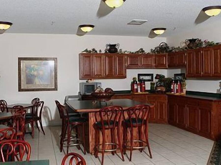 A kitchen with wooden cabinets, a dining table with chairs, and a television.