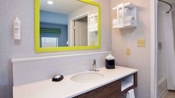 A bathroom with a white sink, a mirror with a yellow frame, a towel rack, and a shower curtain.