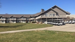 Ein mehrstöckiges Hotel mit überdachtem Parkplatz und Golfcarts.