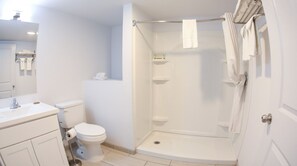A bathroom with a toilet, sink, and shower.