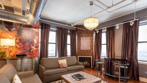 A modern living room with a sofa, ottoman, and a fireplace. - The Giacomo Niagara Falls NY, an Ascend Collection Hotel (Niagara Falls)