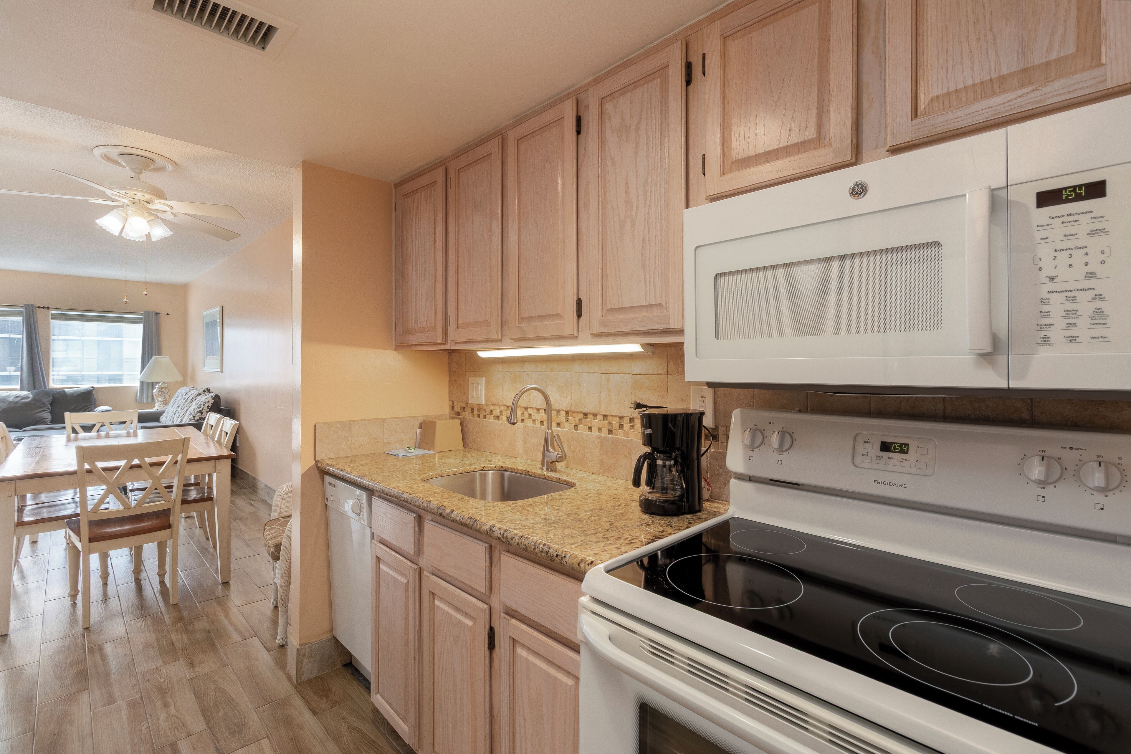 A modern kitchen with wooden cabinets, a white stove, and a built-in microwave.