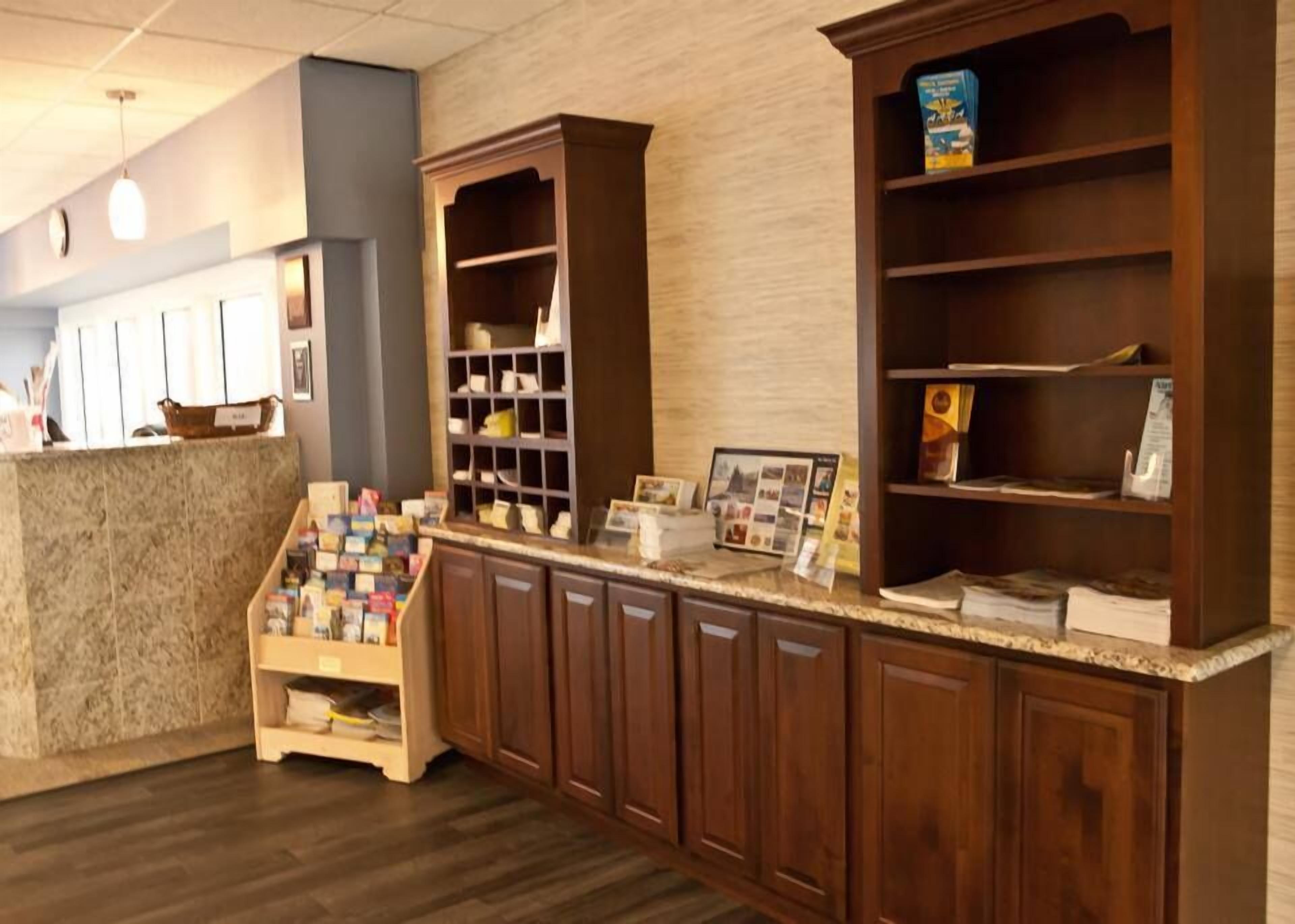 A reception area with a counter, wooden cabinets, and a display of postcards.