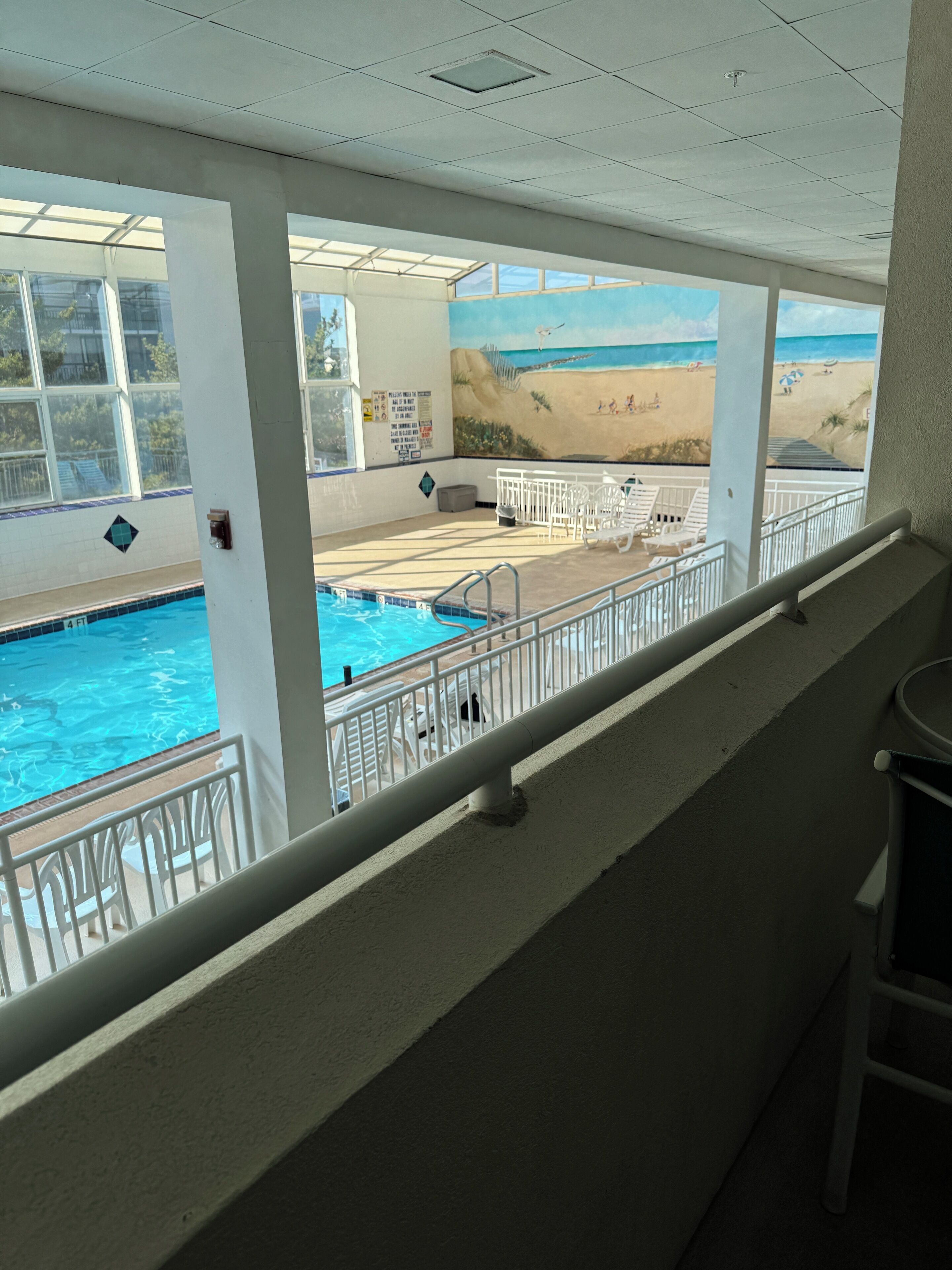 A pool area with a view of a beach.