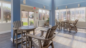 Un espacio interior amplio con muebles de madera y ventanas grandes.