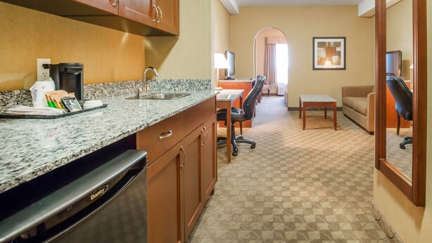 Habitación de hotel con cocina, mesa de comedor y sala de estar.