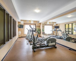 A gym with treadmills, an elliptical, and a stationary bike.