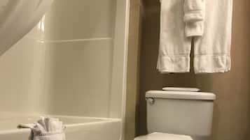 Ein Badezimmer mit Badewanne, Toilette und Handtuchhalter.