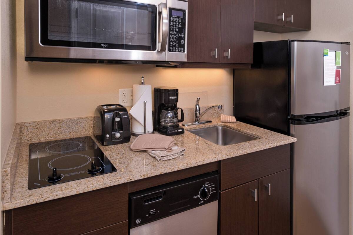 A compact kitchen with a microwave, coffee maker, and dishwasher.