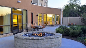 A stone fire pit surrounded by outdoor seating.
