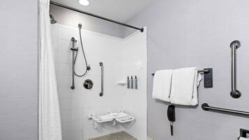 A modern bathroom with a shower, grab bars, a toilet, and a towel rack.