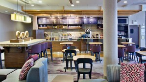 A modern restaurant with a bar area, seating arrangements, and a menu board.