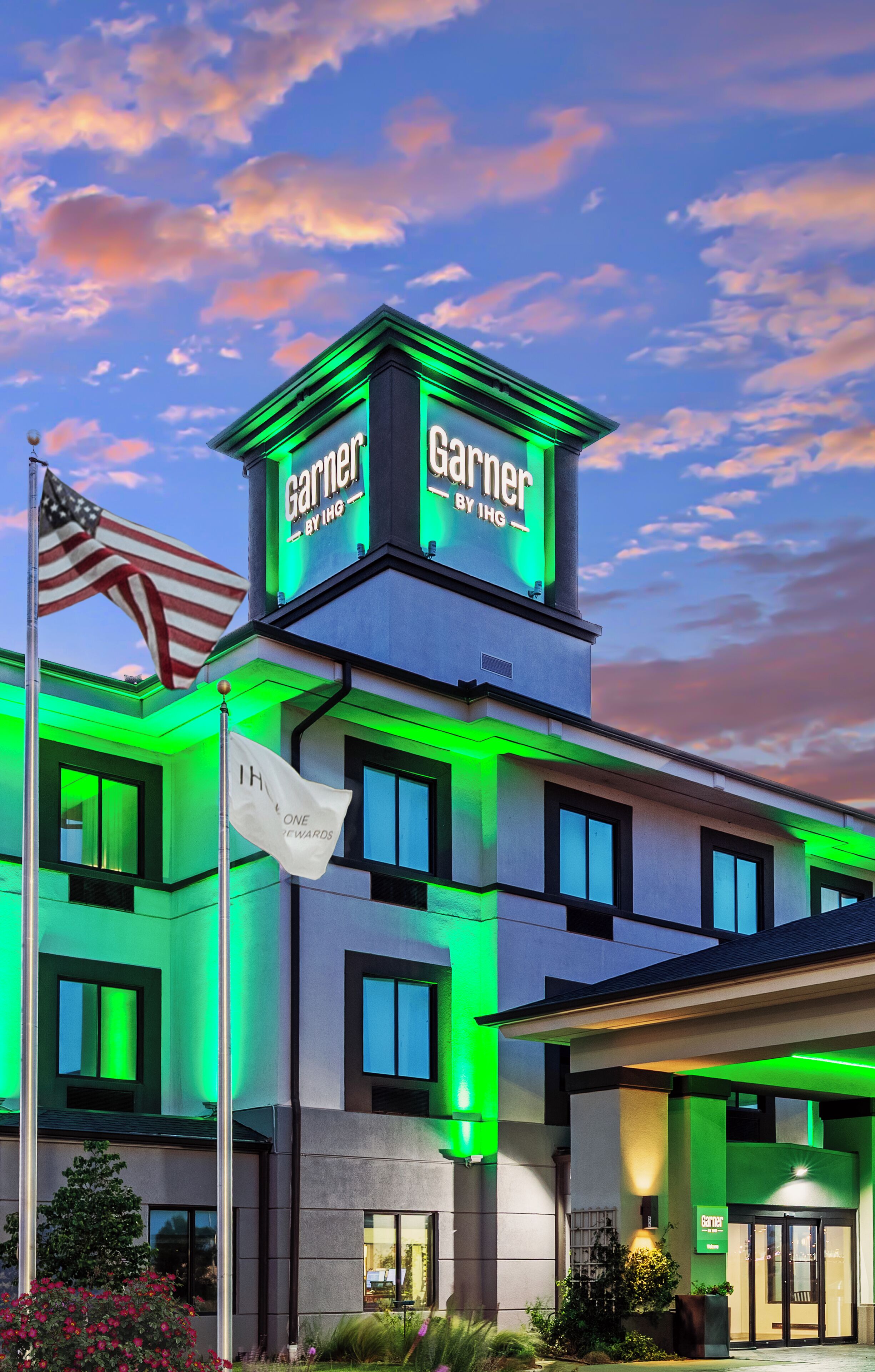 Un hotel con un letrero llamativo en la parte superior, varias ventanas y una bandera.