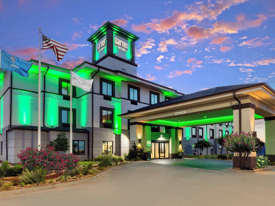 Un hotel de diseño moderno, con una destacada bandera estadounidense y un letrero que dice 'Garner by IHG'.