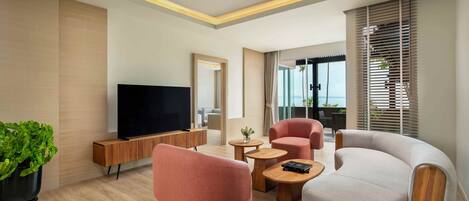 Una sala de estar moderna con un televisor de pantalla plana, dos sofás, una mesa de centro y una planta en maceta.
