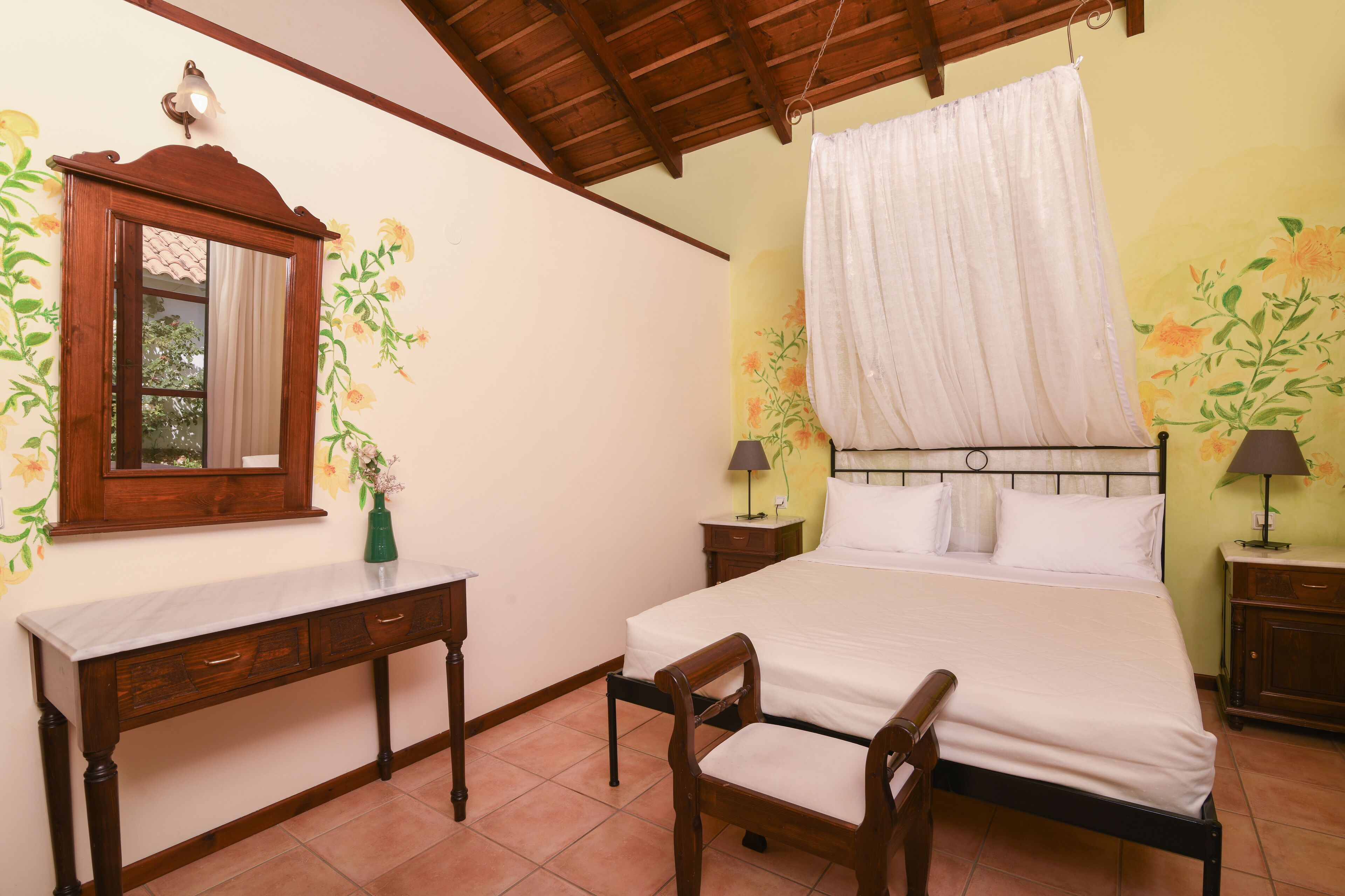 Quarto com uma cama, mesa de cabeceira de madeira, cadeira, espelho e abajur.