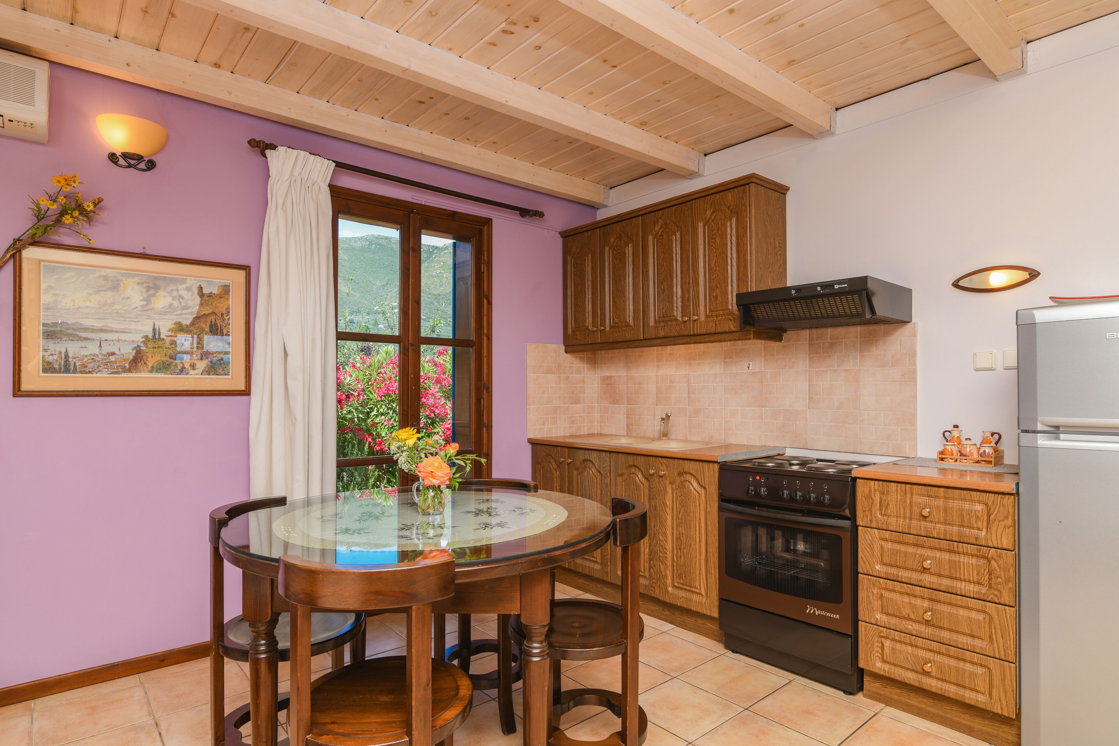 A kitchen with wooden cabinets, a stove, and a dining table with chairs.