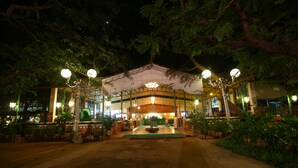 A building with a central courtyard, surrounded by trees and potted plants. - Indeco Mahabalipuram (Tirukalukundram)