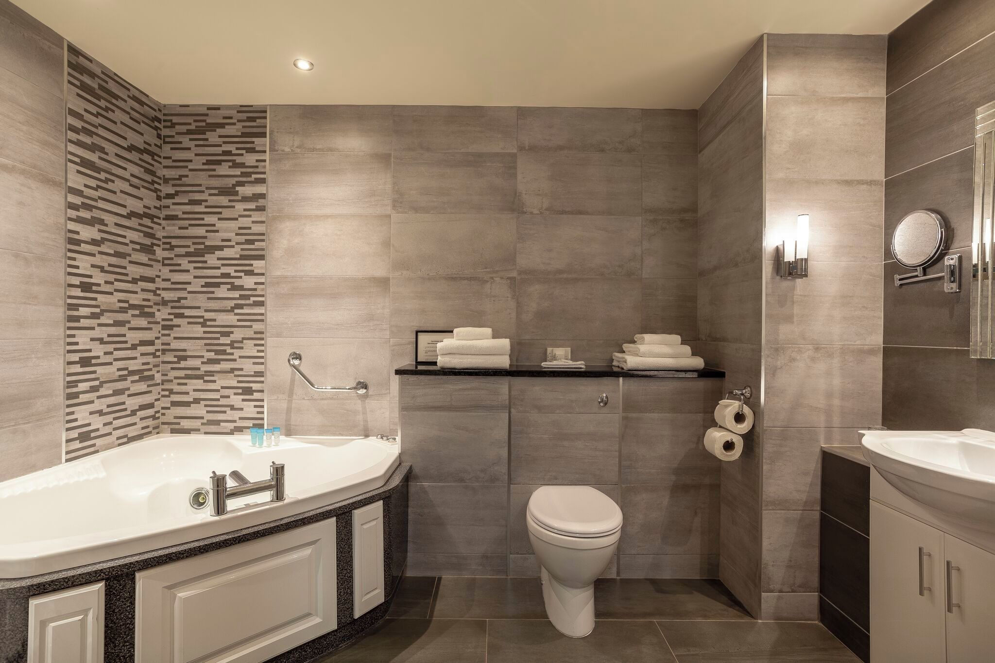 Un baño moderno con bañera, inodoro y lavamanos.