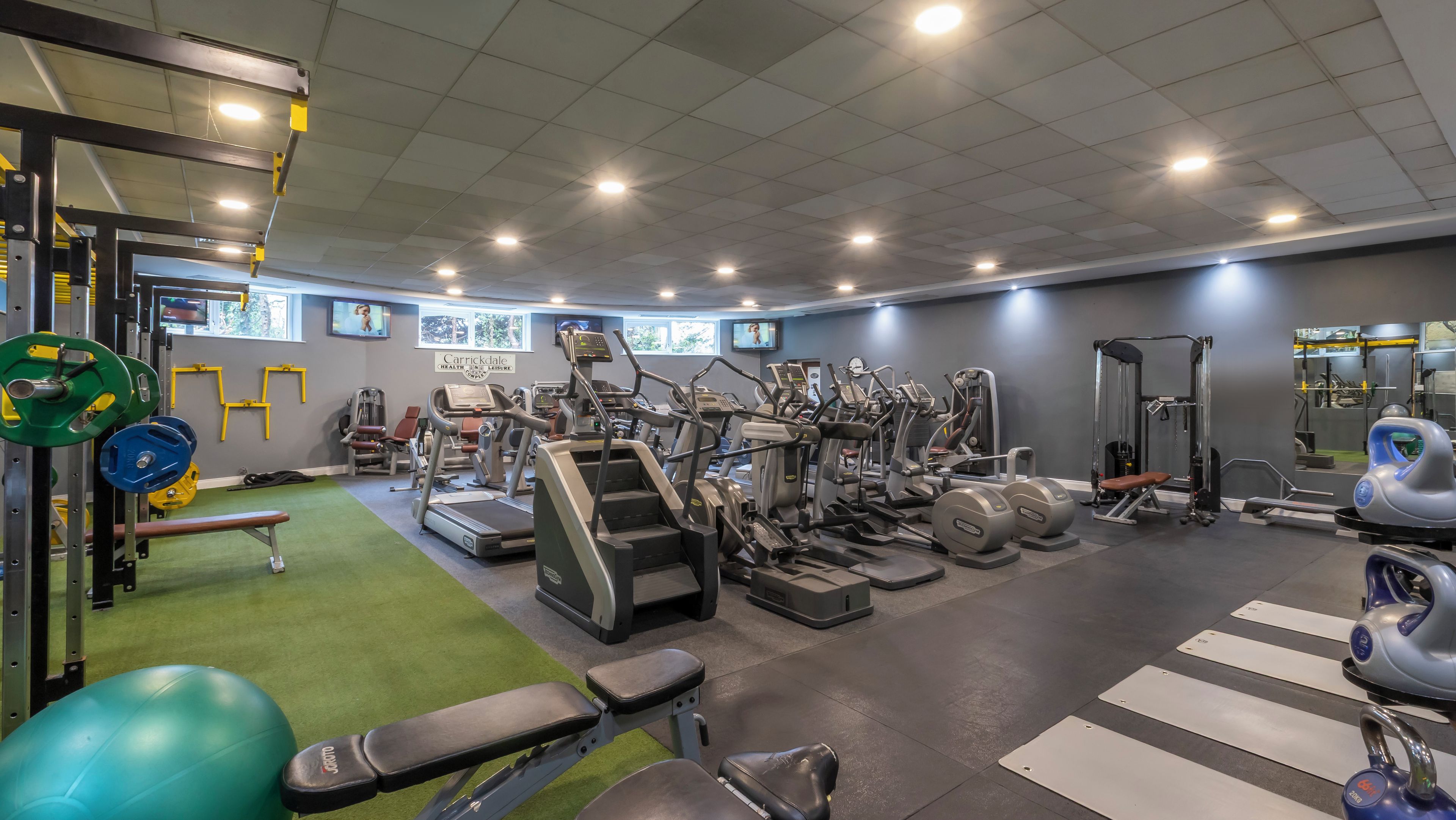 A gym with various exercise equipment, treadmills, and weight machines.