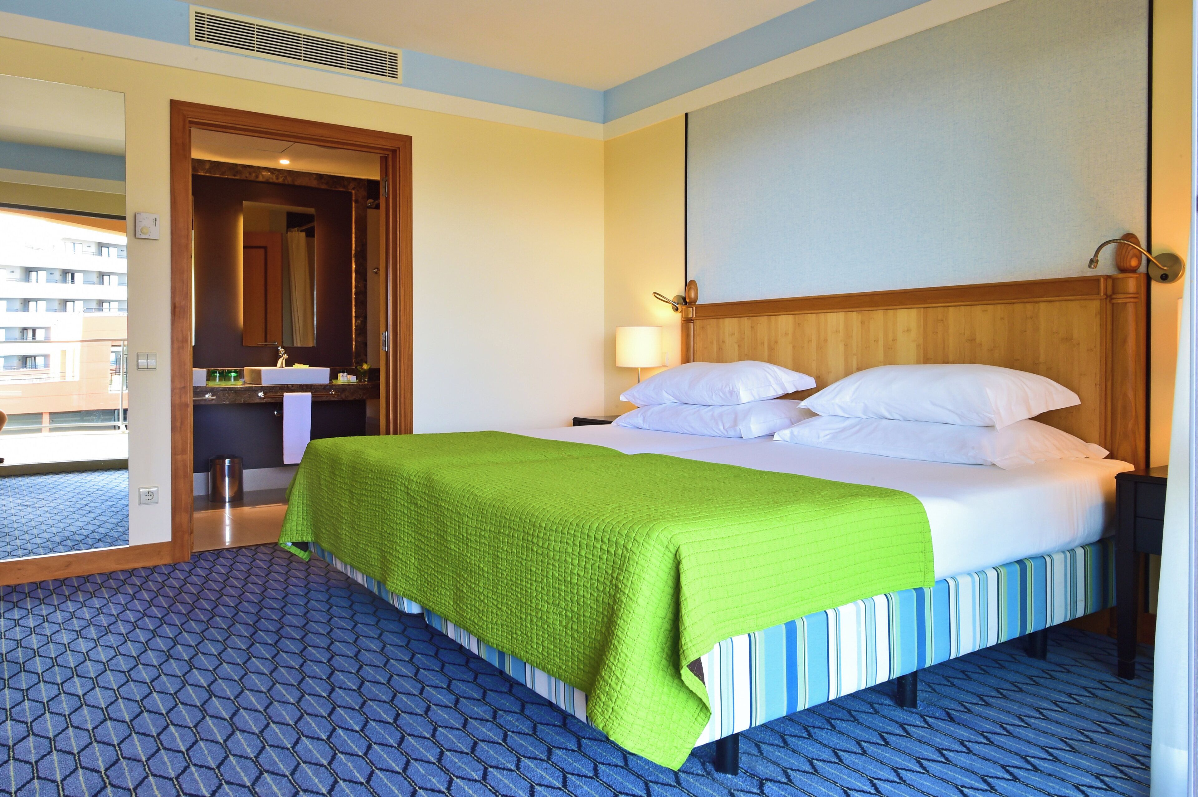Ein Hotelzimmer mit Bett, Bad und Blick ins Freie.