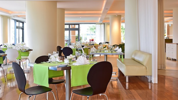 A restaurant with tables set for dining, chairs, and a sofa. - Pestana Promenade Ocean Resort Hotel (Funchal)