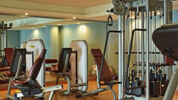 Une salle de sport équipée de divers appareils d’exercice, notamment des tapis de course et des appareils de musculation.