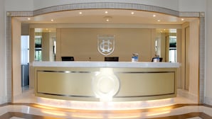 A reception desk with a logo, a counter, and a modern design. - Grand Hotel Duca di Mantova (Sesto San Giovanni)