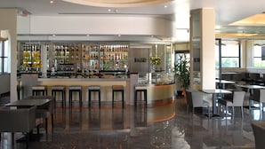 A modern bar area with a polished floor, a central bar counter, and seating arrangements. - Grand Hotel Duca di Mantova (Sesto San Giovanni)