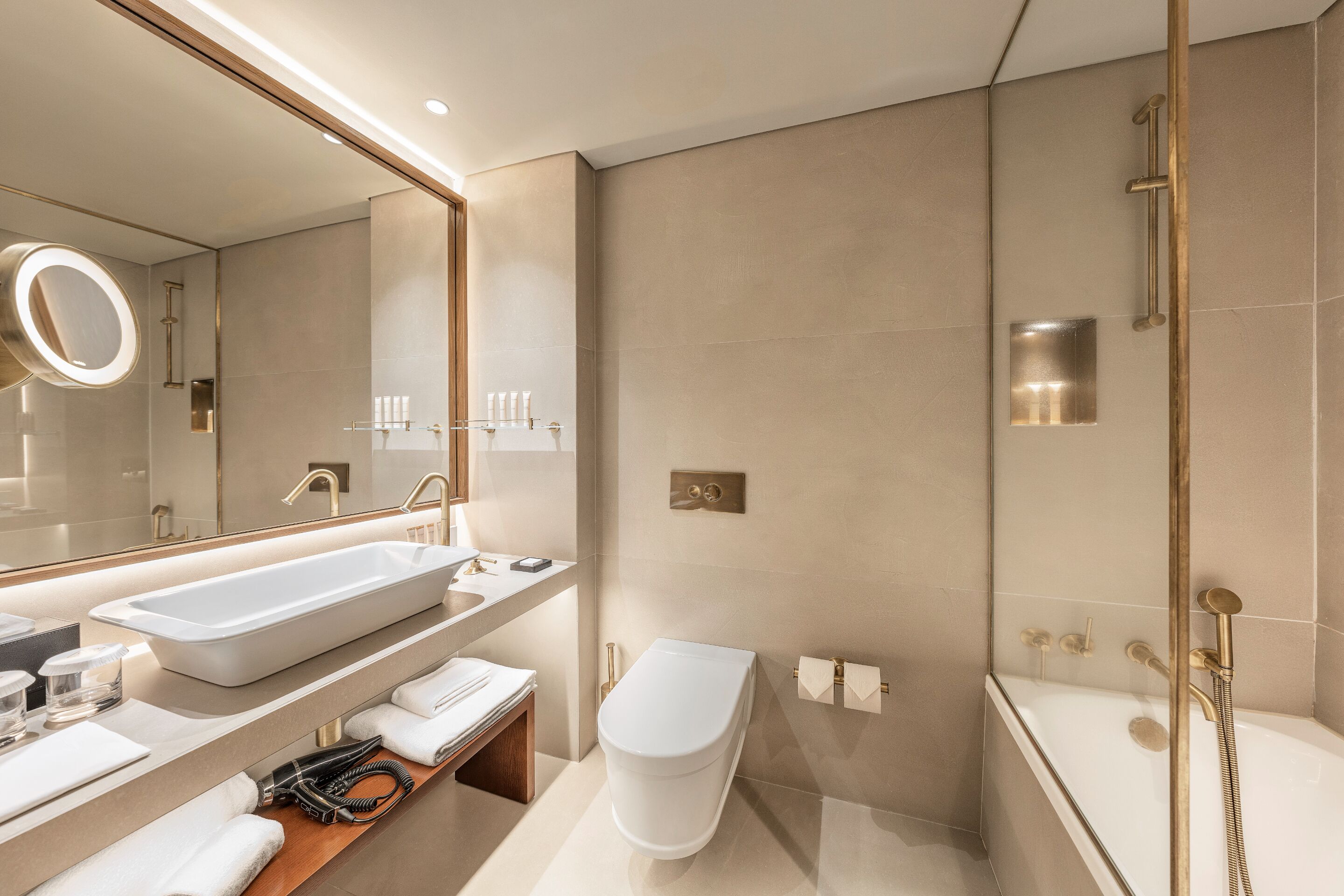 A modern bathroom with a large sink, toilet, and bathtub.