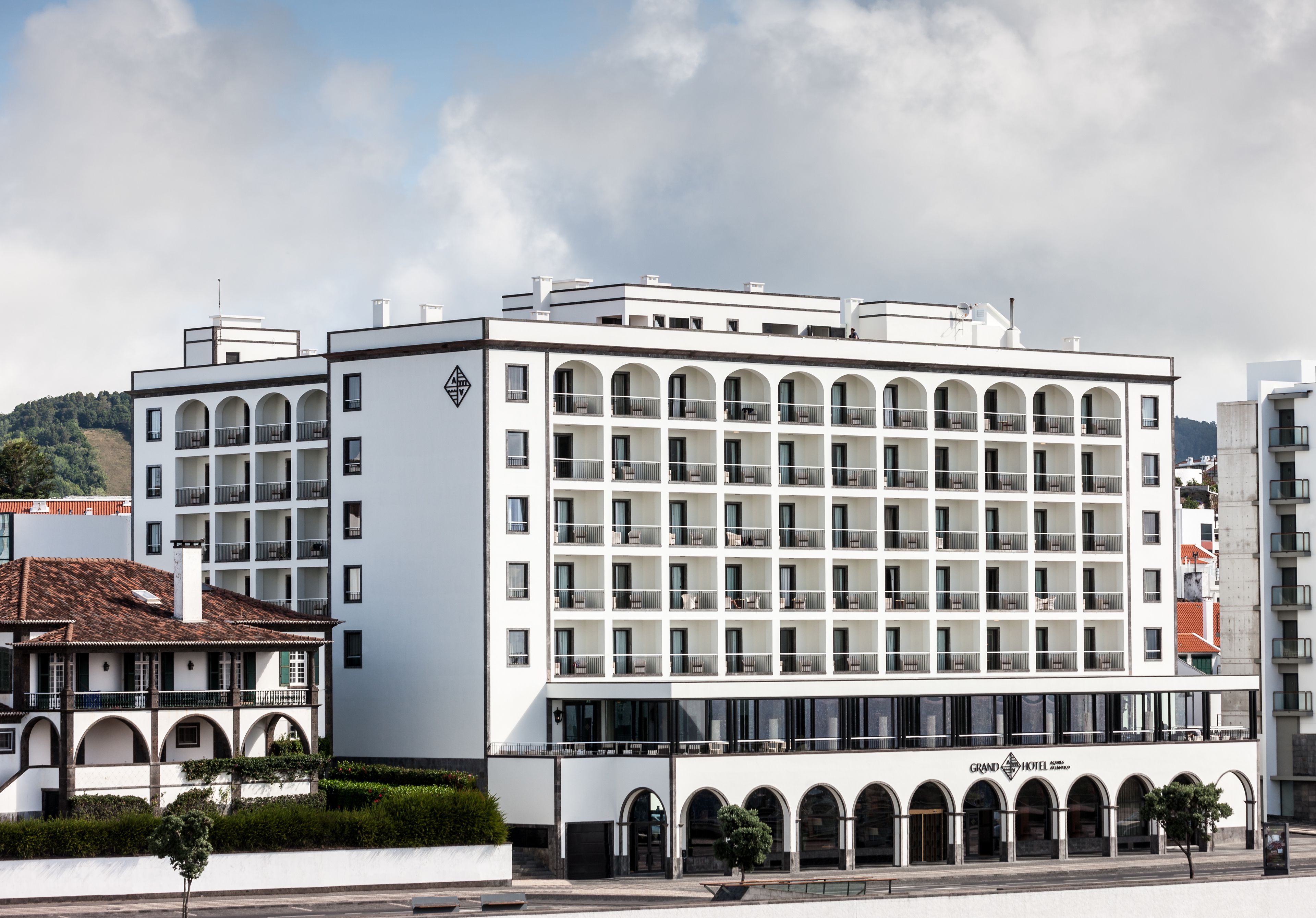 A modern hotel with multiple floors, balconies, and a prominent entrance.